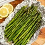 Fresh Asparagus in foil with a side of slice lemons.
