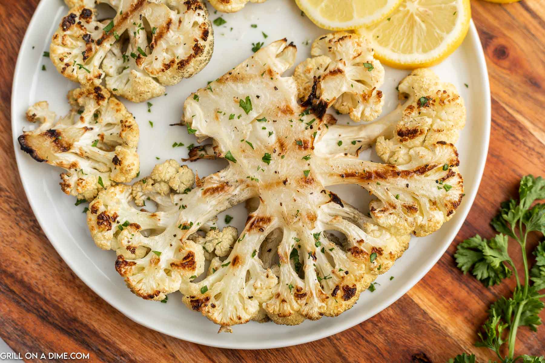 Cauliflower Steaks on a plate with fresh lemon slices