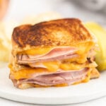 Grilled Ham and Cheese cut in half stacked on a plate