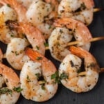 Grilled shrimp on skewers with herbs.