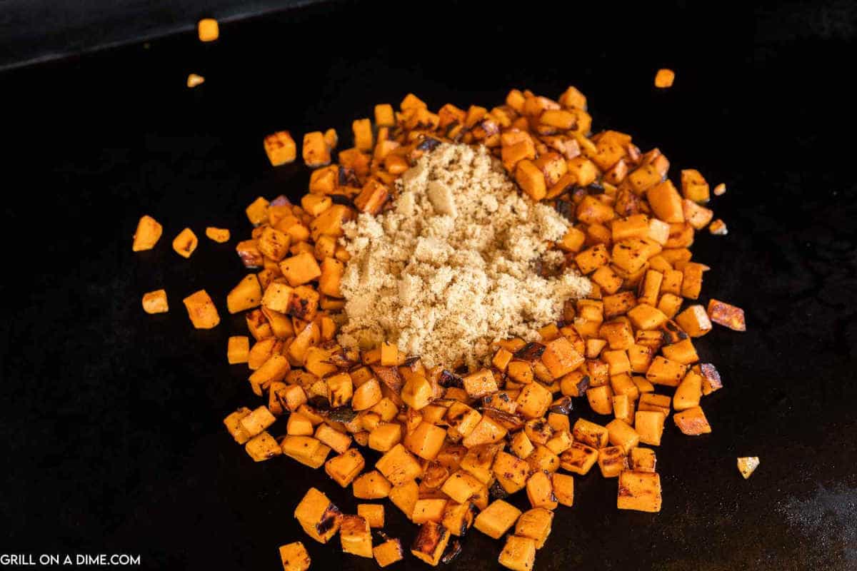 Cooking the sweet potatoes on the griddle topped with brown sugar.