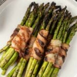 Bacon wrapped asparagus stacked on a plate