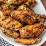 Grilled chicken wings on a white plate.