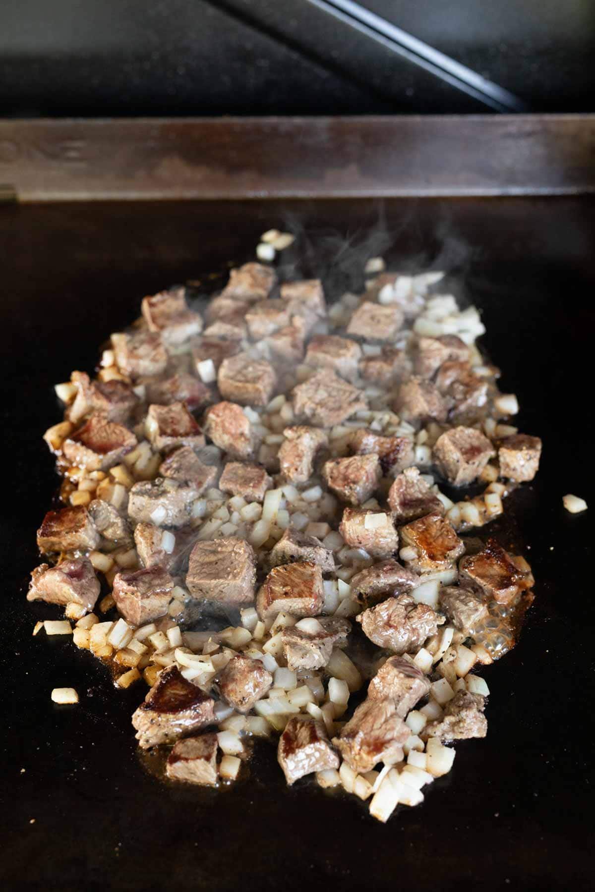 Cooked steak bites and onions on the Blackstone Griddle