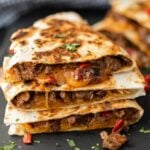 A stack of quesadillas with meat and cheese.