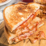 Grilled Peanut Butter and Jelly cut in half and stacked on a plate
