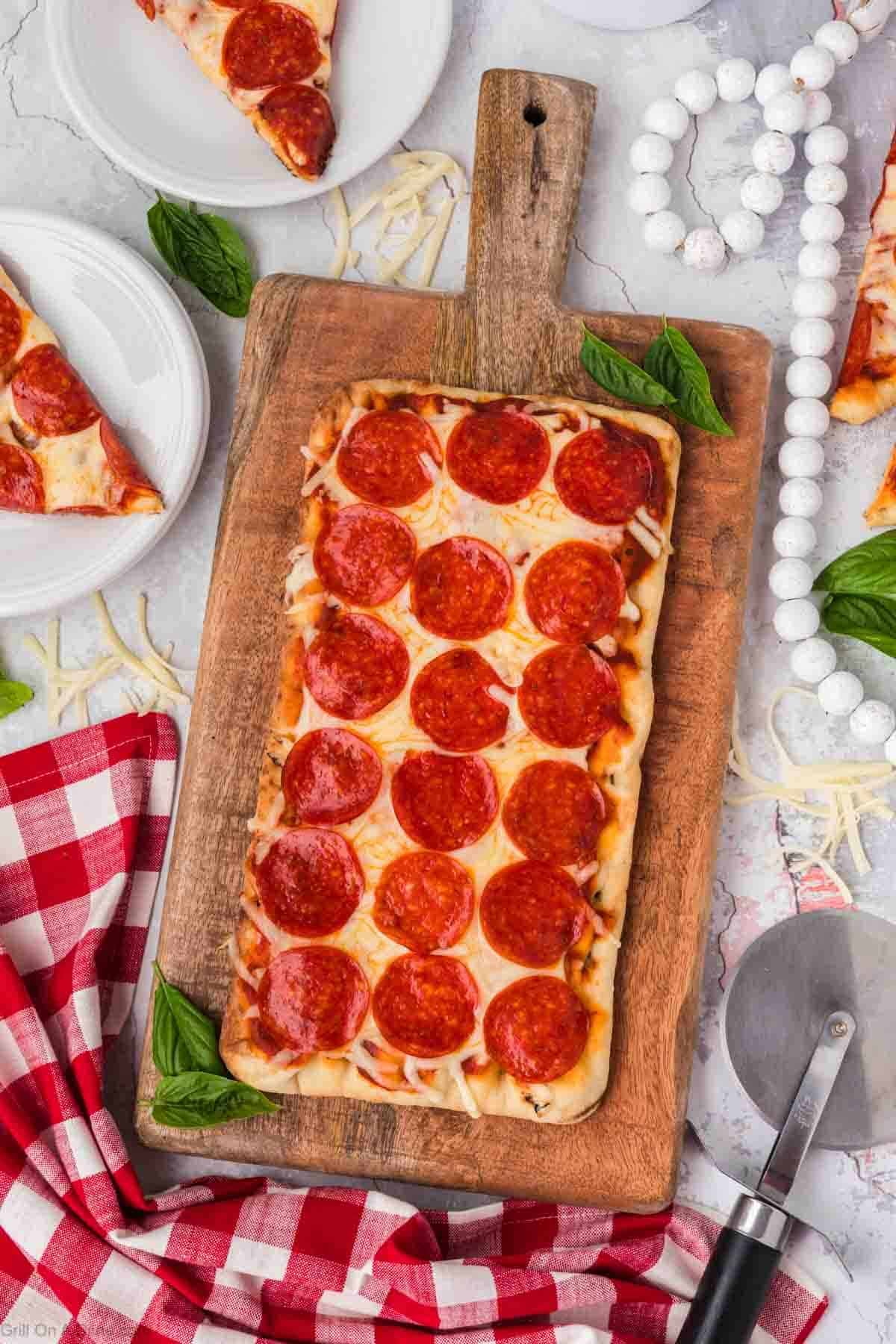 Cooked flatbread pizza on a cutting board