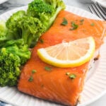 Salmon and broccoli on a white plate.
