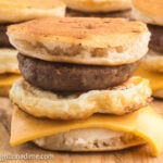 Blackstone McGriddle layered with sausage and cheese on a wooden platter.