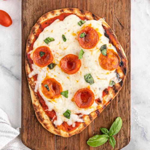 Flatbread Pizza topped with slice pepperonis and fresh herbs