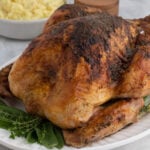 Juicy roasted whole chicken with crispy, seasoned skin, served with herbs and mashed potatoes. Perfect for family dinners or special occasions.