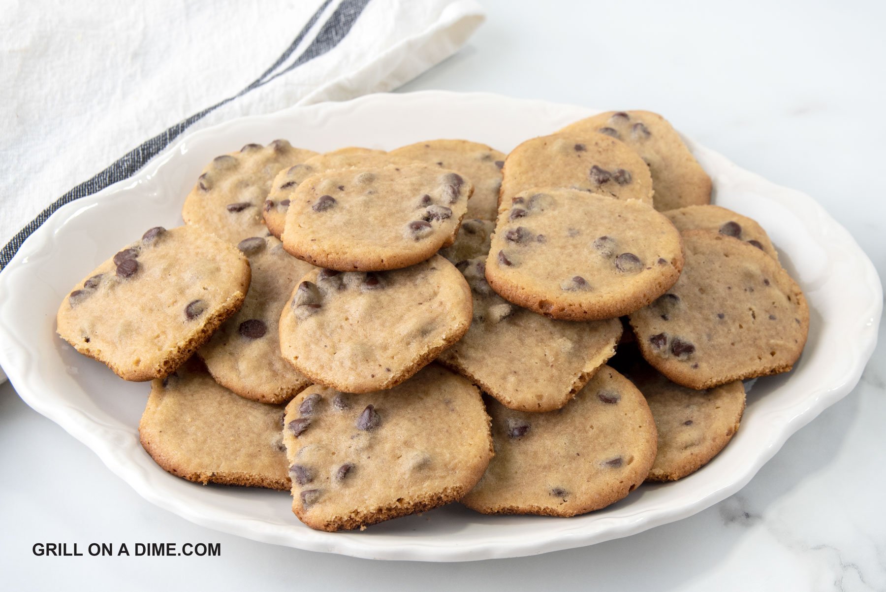 Chocolate Chip Cookies stacked on a white a platter