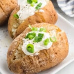 Baked potatoes with sour cream and green onions.