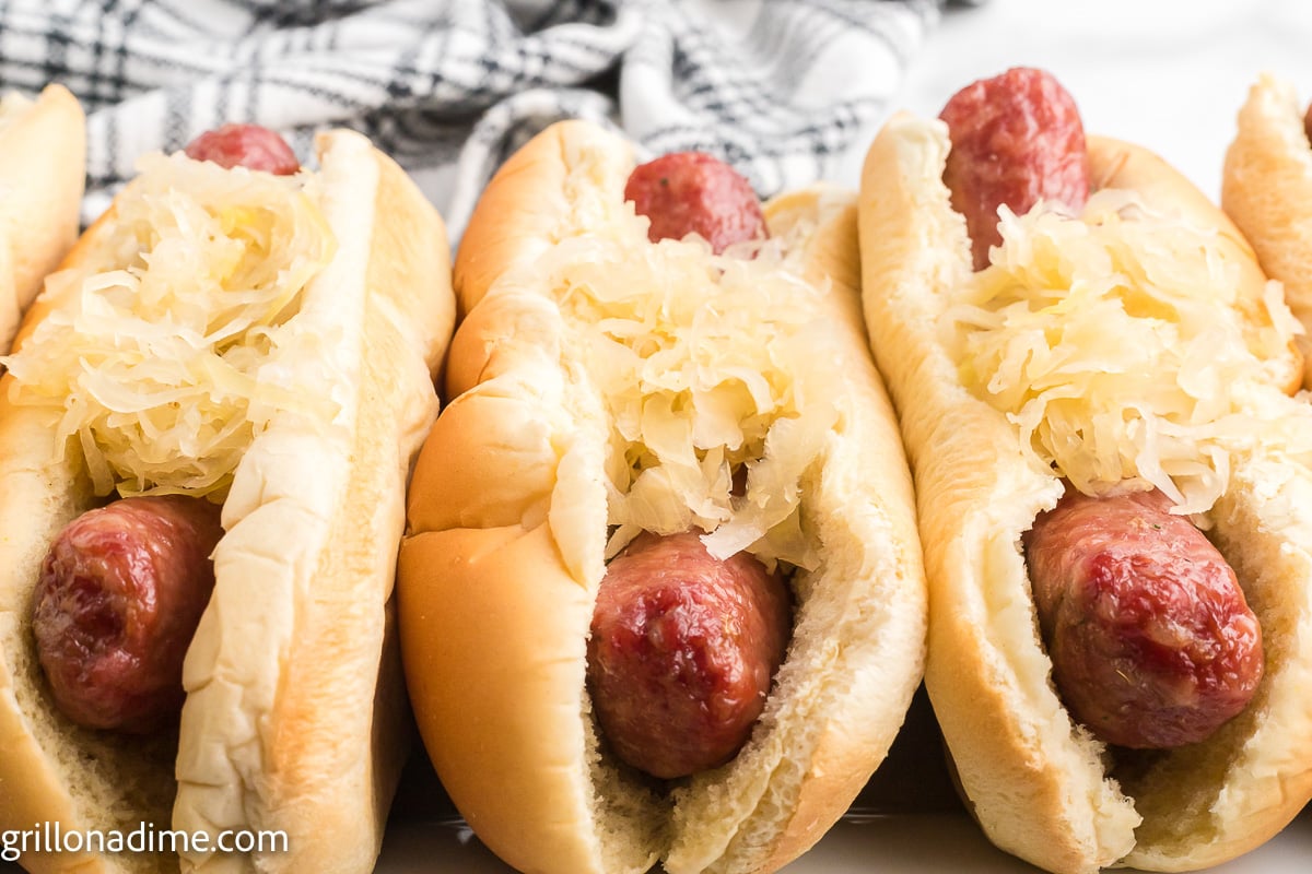 Smoked Brats in hot dog buns topped with sauerkraut