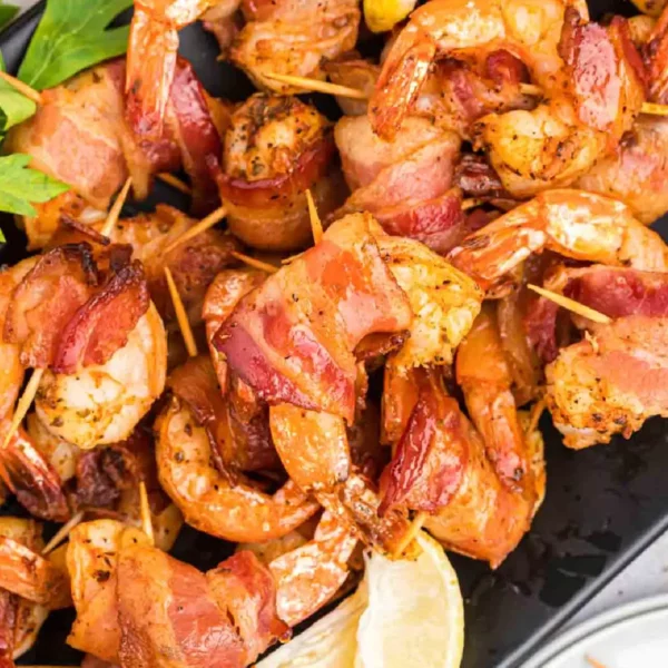 Grilled Bacon wrapped shrimp stacked on a plate