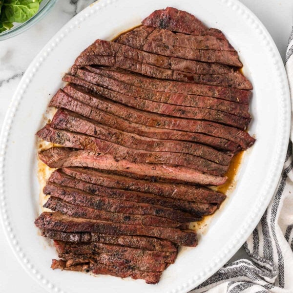 Sliced steak on a white plate.
