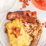 Bacon and eggs on a plate with a fork.