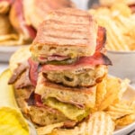 Cuban Grilled Sandwich on a plate with a side of potato chips