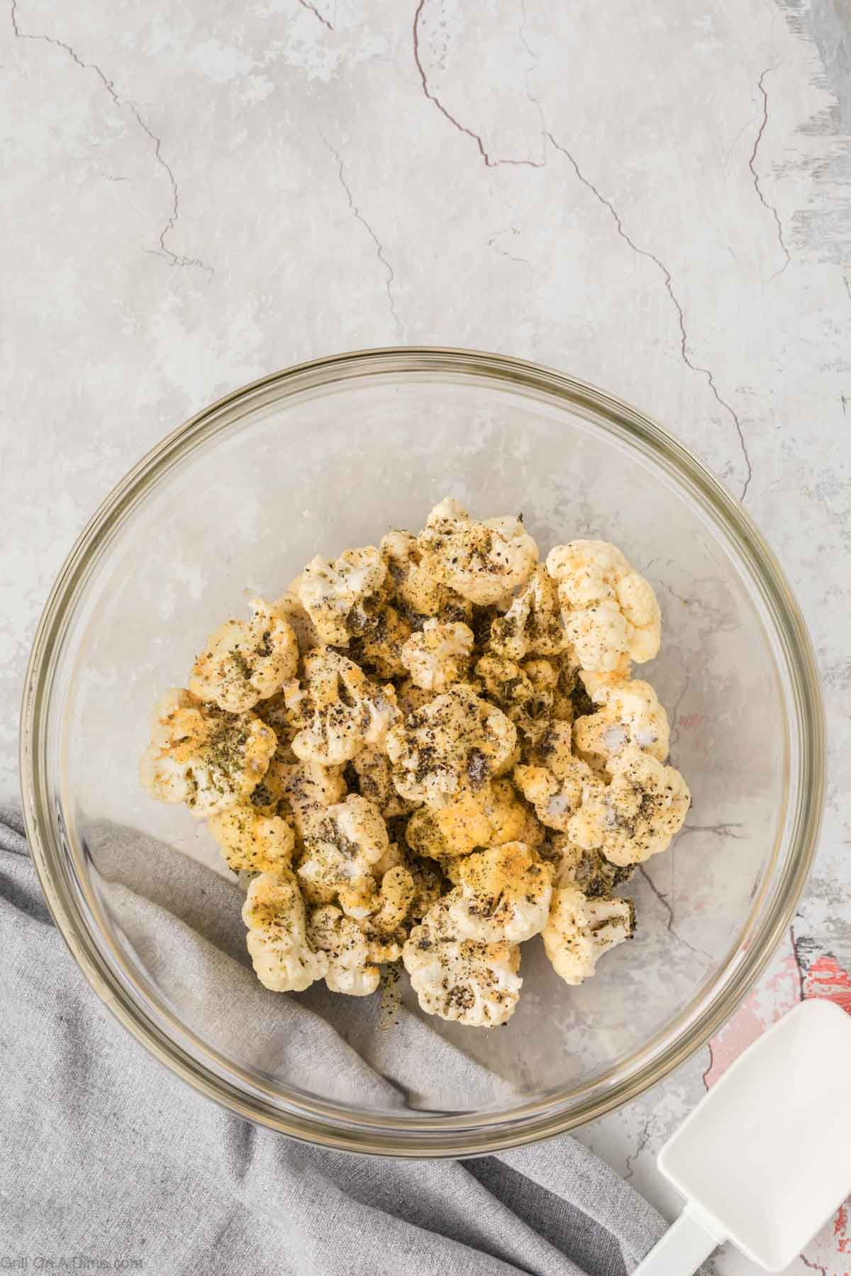 Combining the cauliflower with seasoning