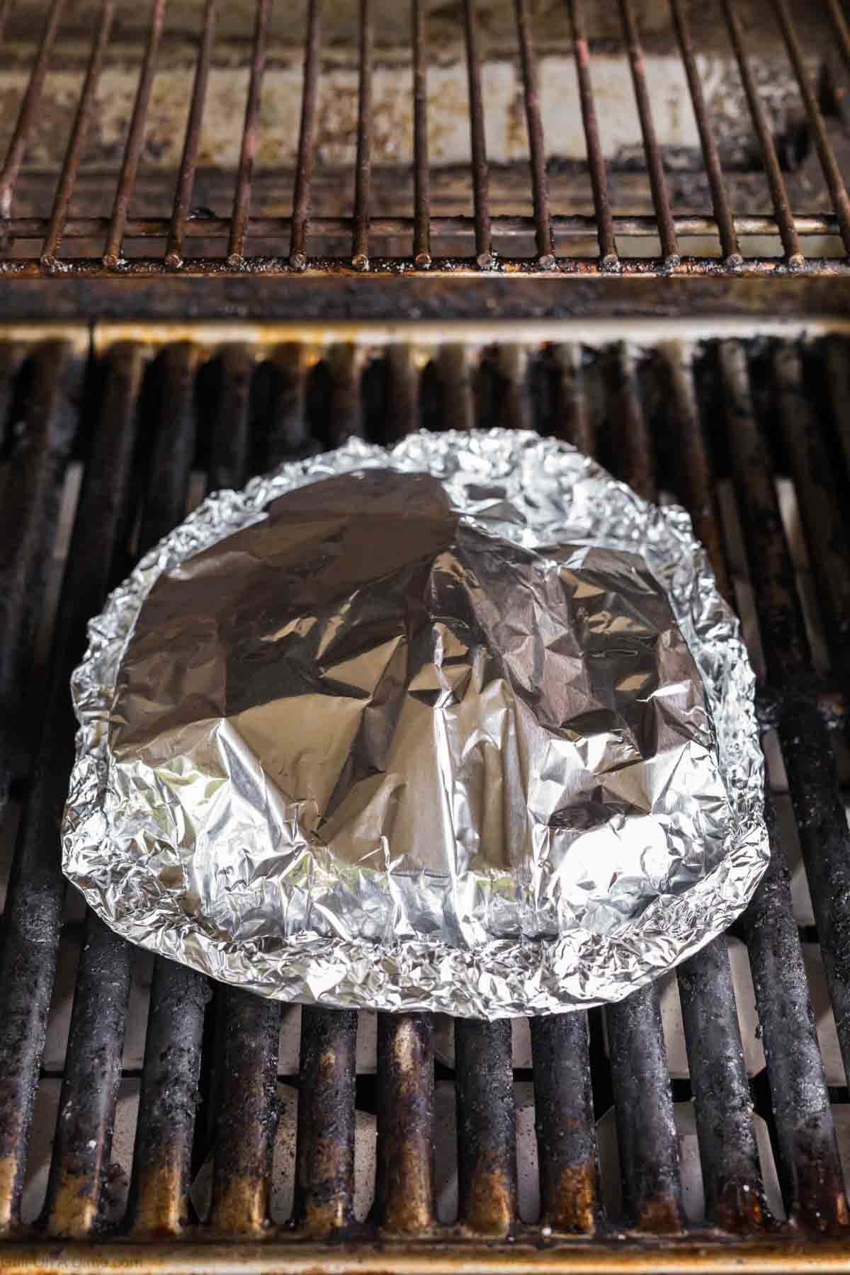 Placing the foil pack on the grill grates