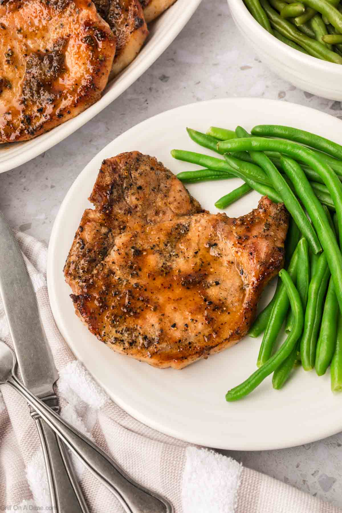 Grilled Maple Glazed Pork Chops on a plate with a side of green beans