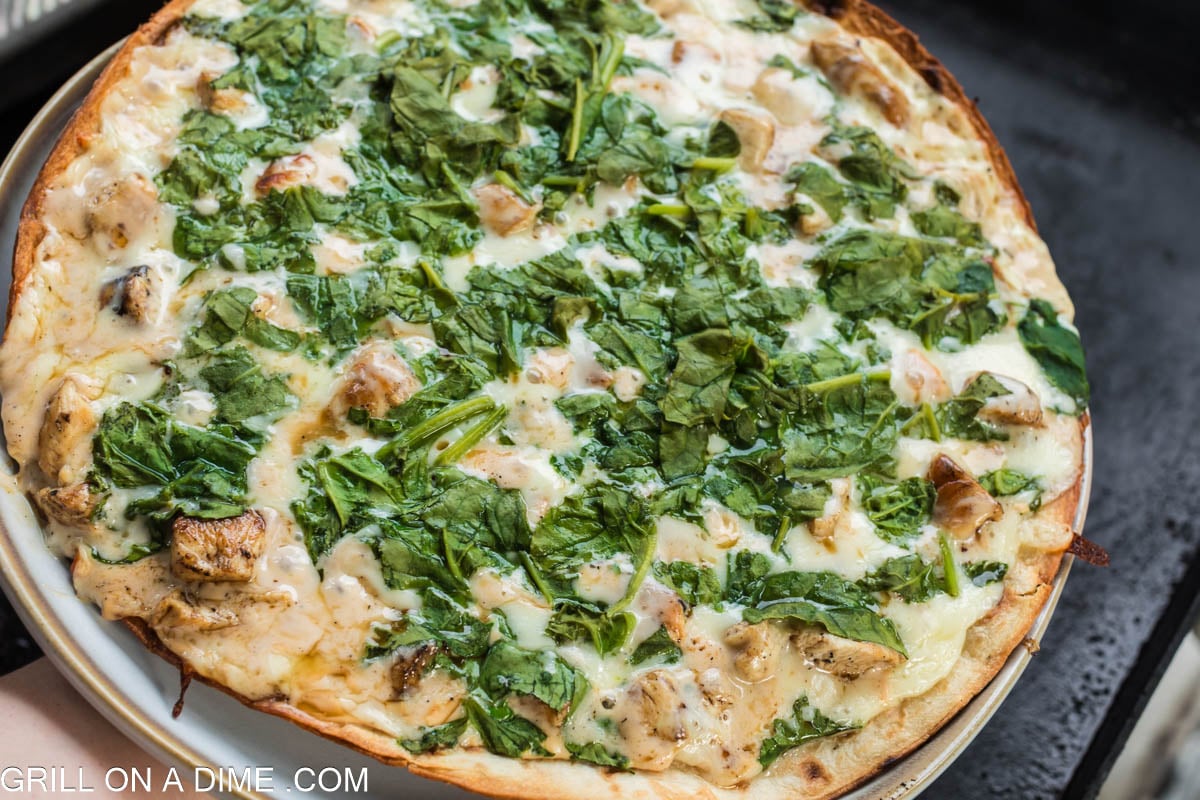 cooked chicken alfredo pizza on the blacktone griddle