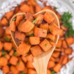 Diced sweet potatoes in a wooden spoon