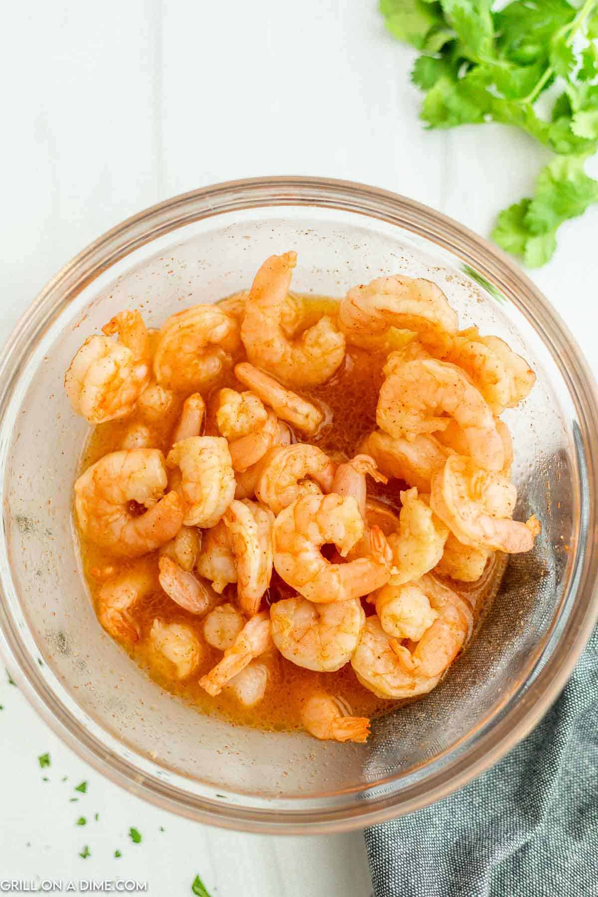 Shrimp marinating in the marinade in a bowl. 