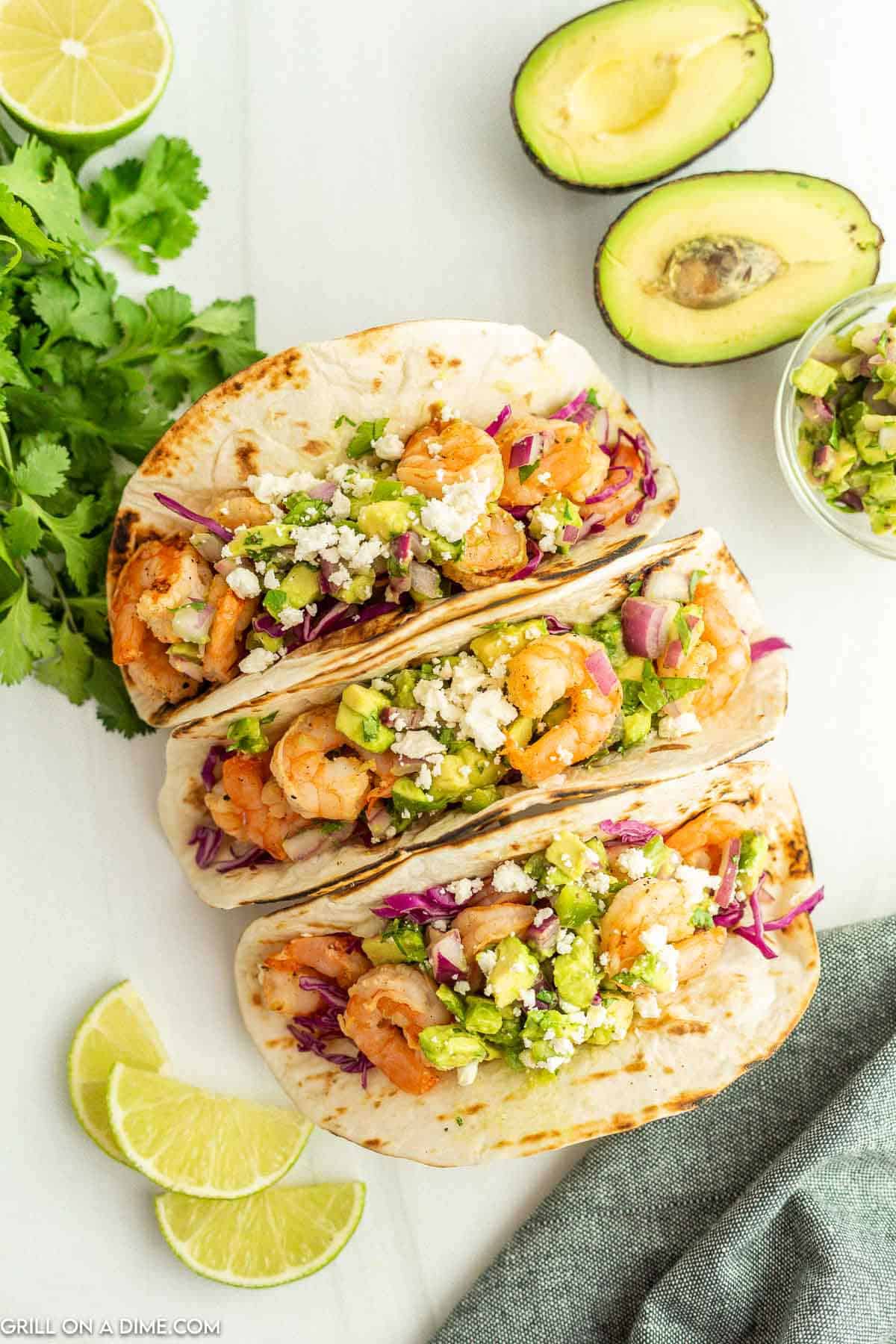 Shrimp Tacos topped with diced avocado and cojita cheese. 