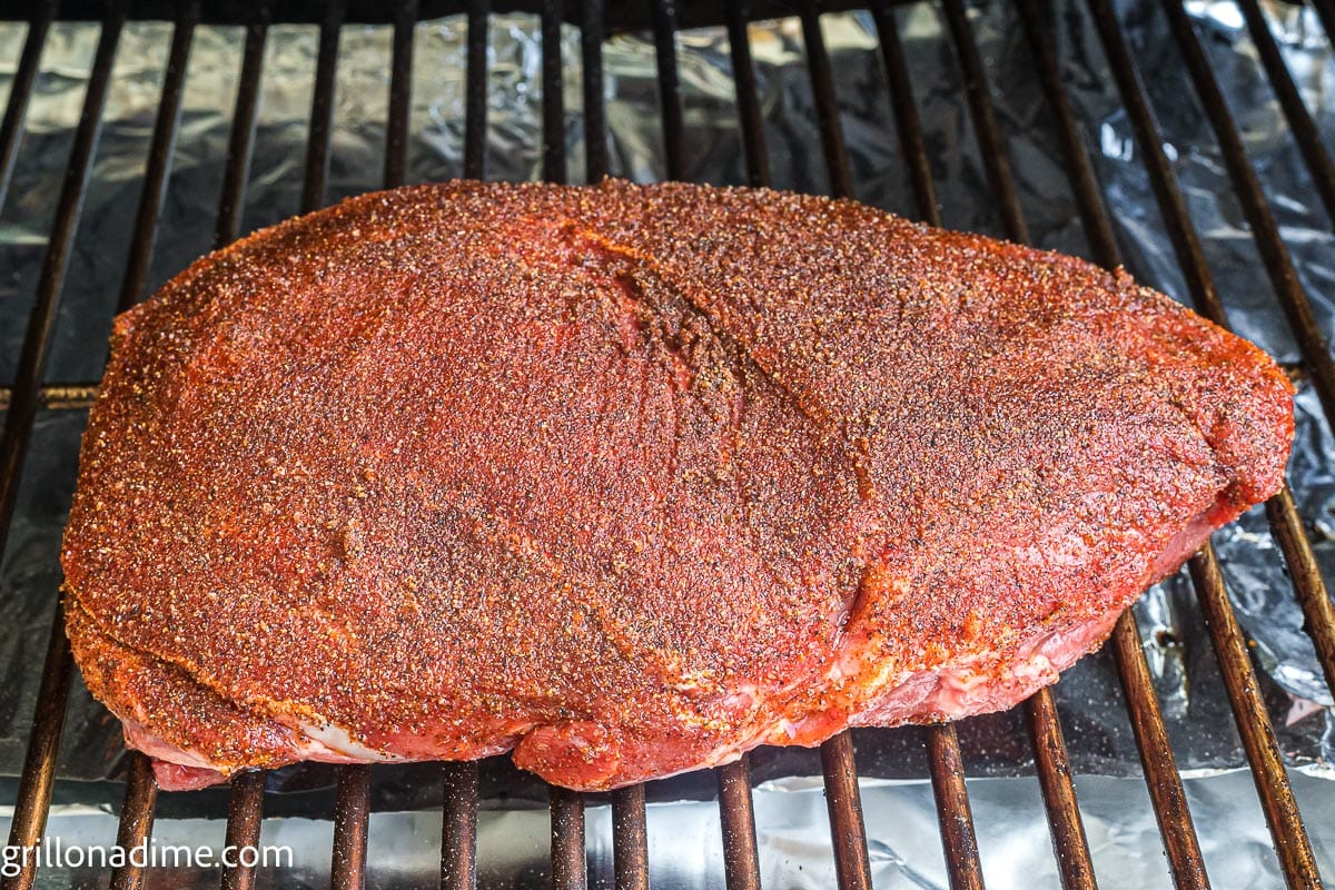 Placing the seasoned beef roast on the grill grates