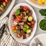Steak bites with grilled mushrooms, red onions, and zucchini on a platter