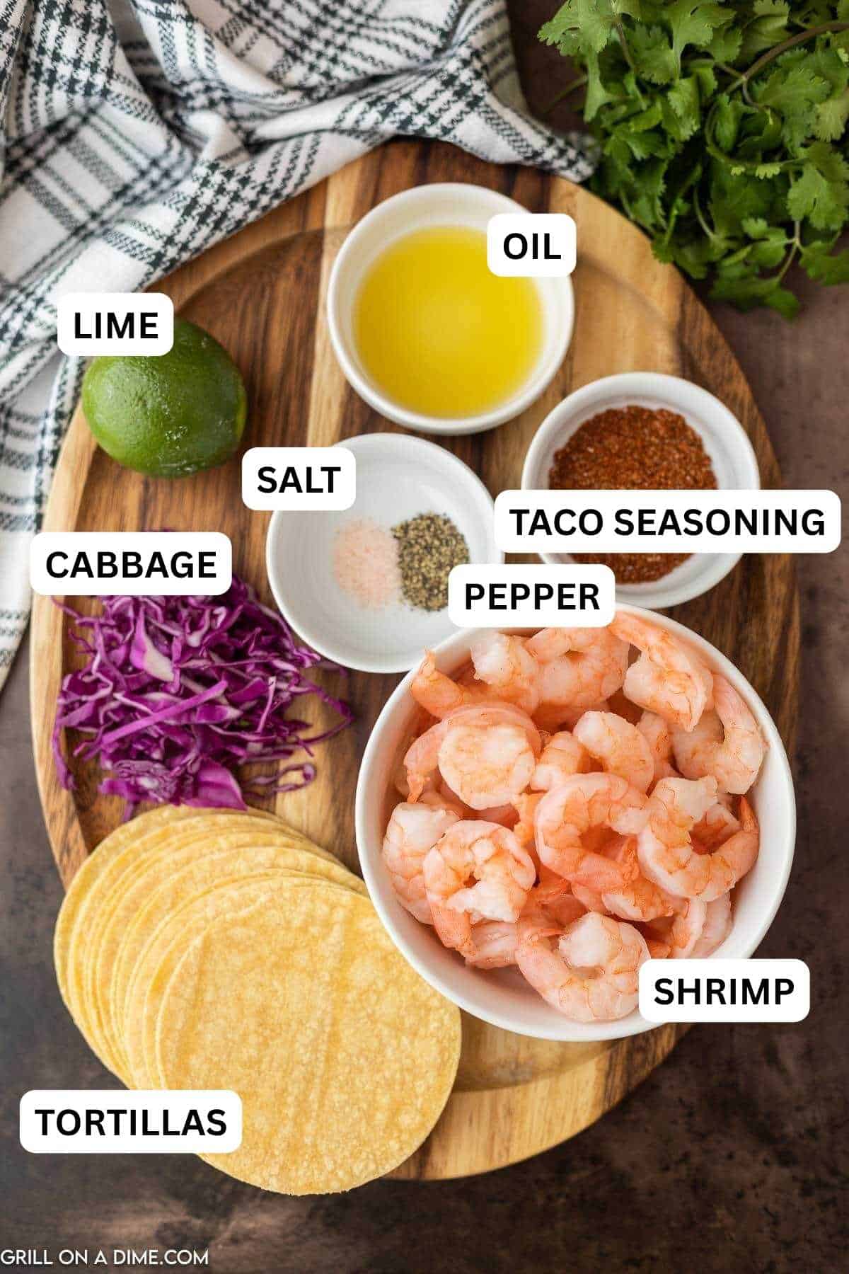 Ingredients needed to make this recipe which includes shrimp, taco seasoning, lime, vegetable oil, salt and pepper, corn tortillas, red cabbage and cojita cheese.
