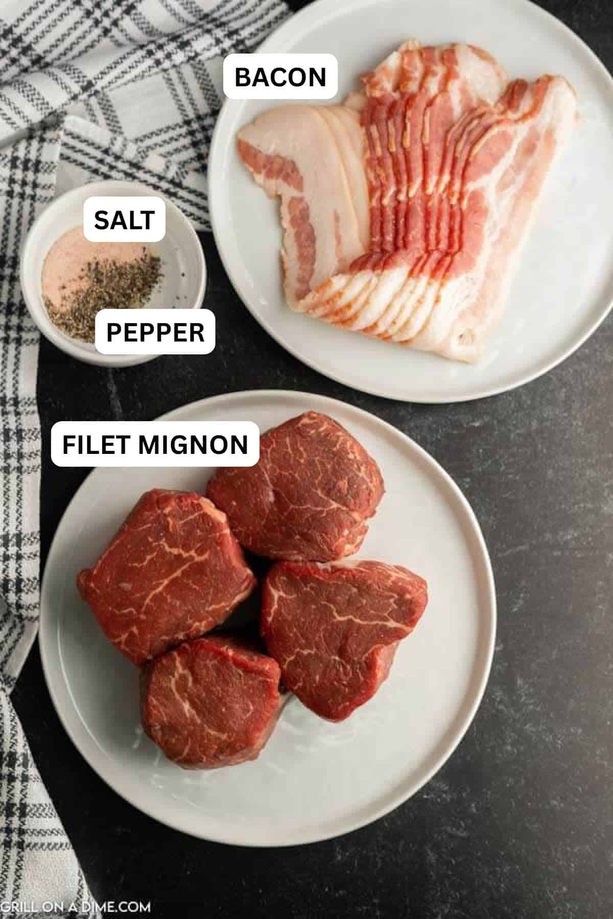 Ingredients needed to make this recipe which includes a Filet Mignon, bacon slices on a plate with a bowl of spices.