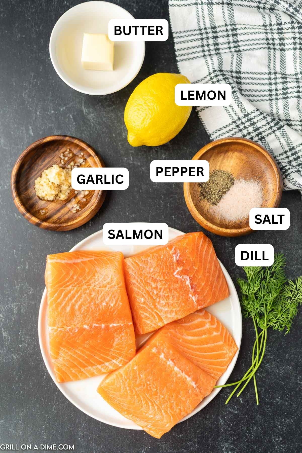 Ingredients needed to make this recipe which includes salmon, garlic, lemon, dill, salt, pepper, and butter.