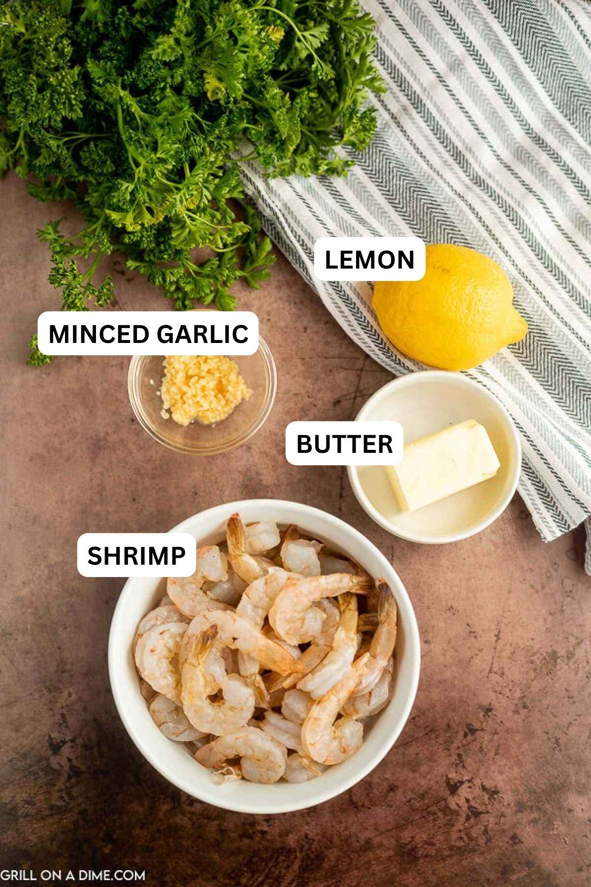 Ingredients needed needed to make this recipe which includes raw shrimp, parsley, butter, lemon, and minced garlic.