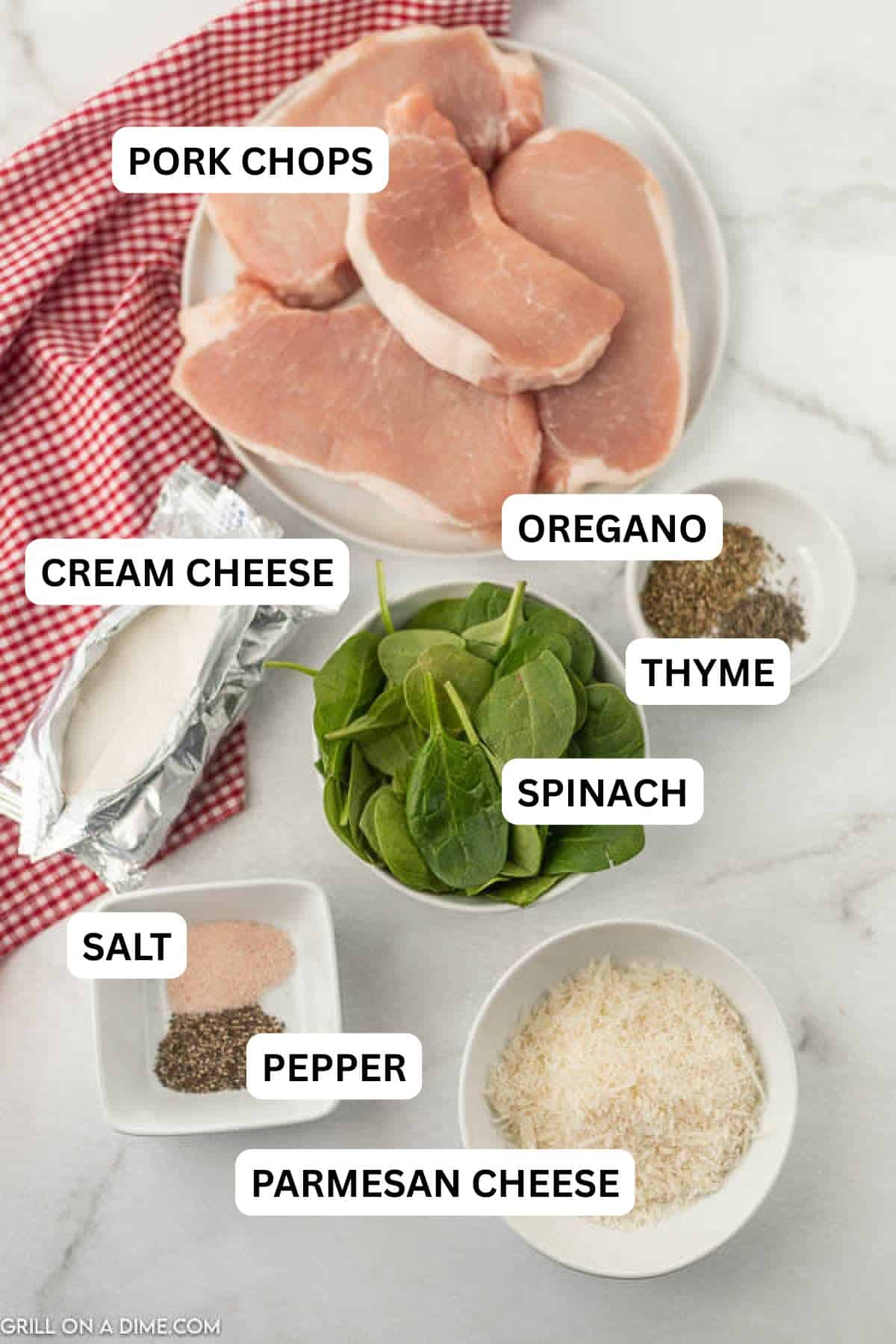 Ingredients needed to make this recipe which includes pork chops, cream cheese, parmesan cheese, spinach, thyme leaves, oregano, salt and pepper.