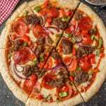 Crispy pepperoni pizza with ground beef, red onions, green peppers, and tomato sauce.