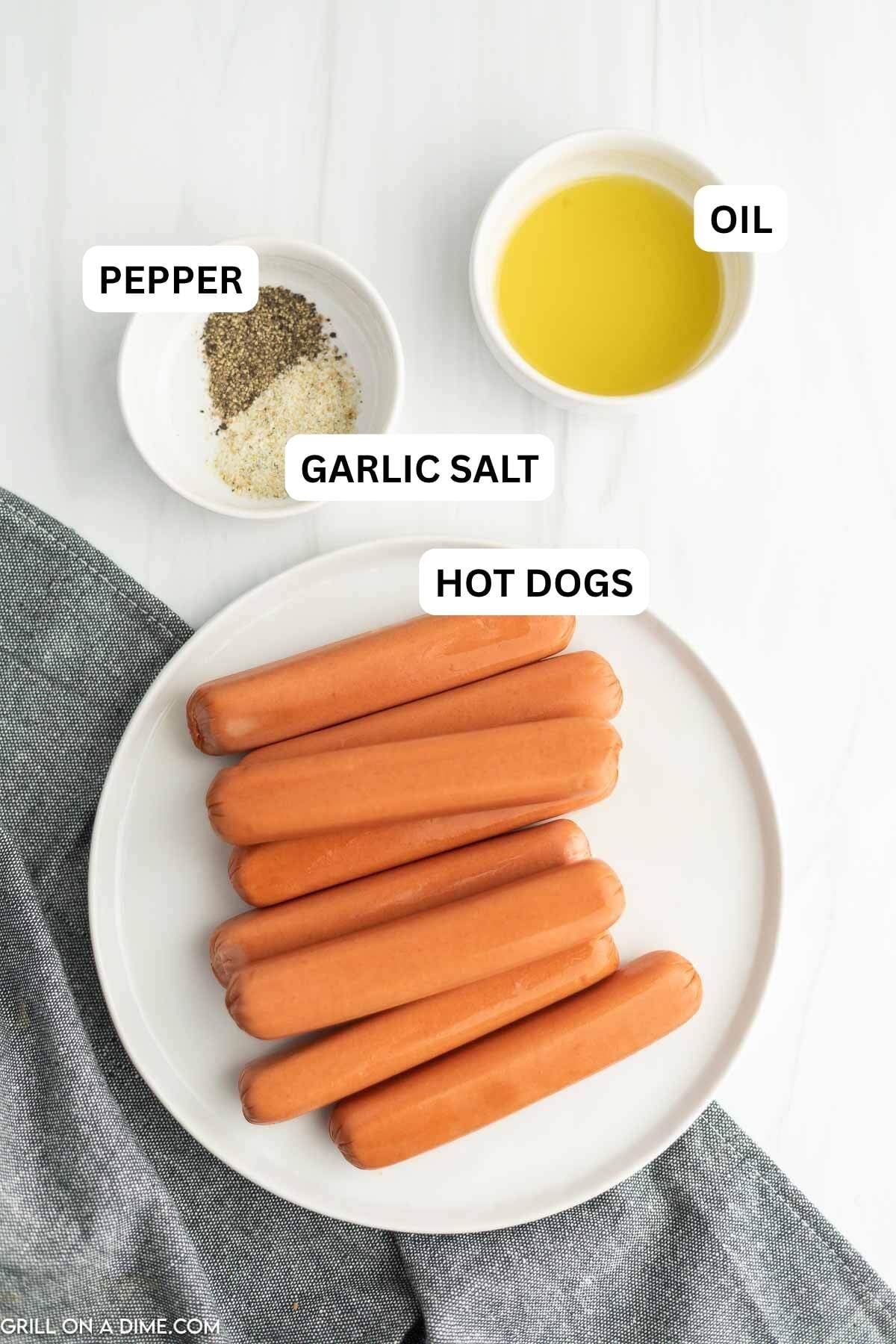 Ingredients needed to make this recipe which includes hot dog, hot dog buns, oil, garlic salt, and pepper.