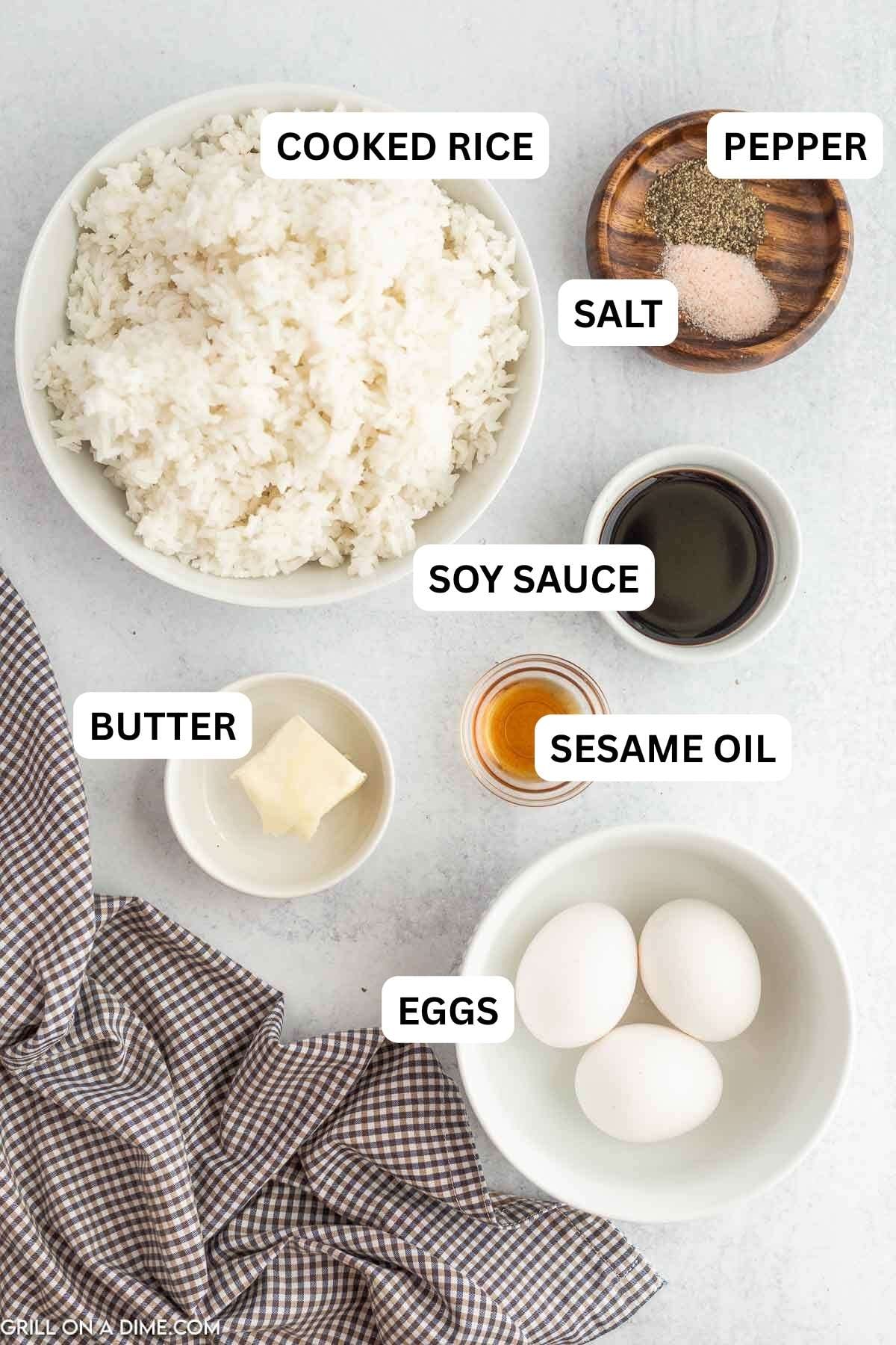 Ingredients needed to make this recipe which includes butter, cooked rice, sesame oil, soy sauce, salt and pepper, and eggs.