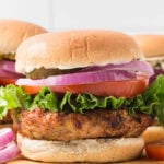Turkey burgers with lettuce, tomato, onion and pickles.