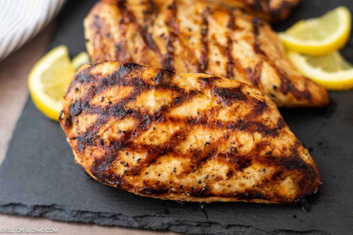 Grilled Lemon Pepper Chicken on a platter with slices of lemon.