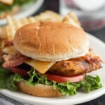 A chicken sandwich with bacon, lettuce and cheese.