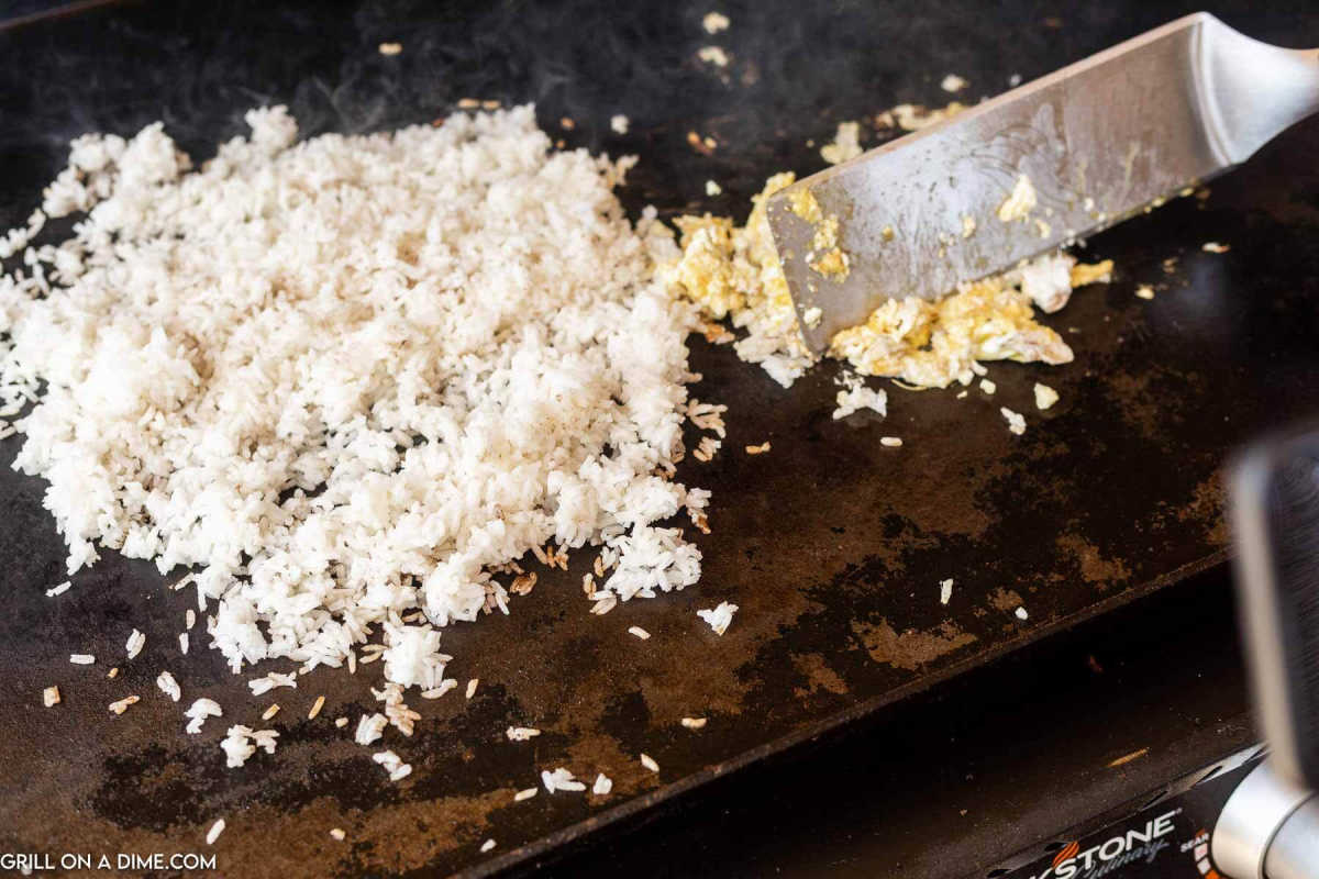 Cooking fried rice on the griddle with some scrambled eggs.