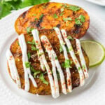 Grilled Mangos topped with a white cream sauce and fresh herbs