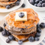 Fluffy blueberry pancakes topped with butter and fresh blueberries, perfect for breakfast or brunch.