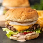 Savory cheeseburger with lettuce, tomato, onions, and melted cheese on a toasted bun. Perfect for burger lovers and cookout recipes.