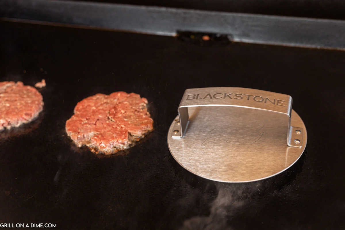 Cooking hamburger patties on the griddle with a hamburger press.