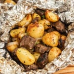 Grilled steak and potatoes in foil.