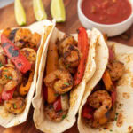 Grilled shrimp tacos with peppers and tomatoes.
