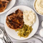 Grilled Pork Chops on a plate with a side of mashed potatoes and green beans